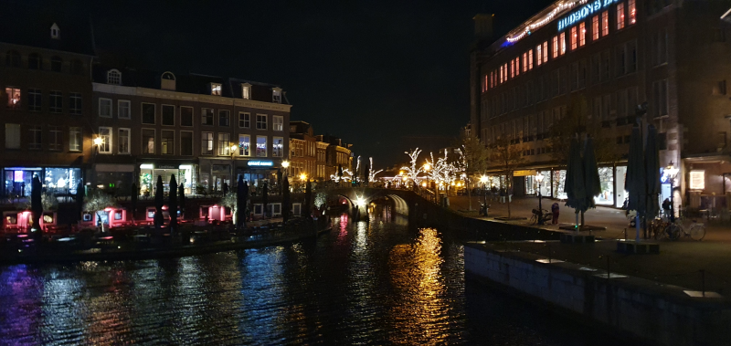Picture of the city centre of Leiden with lit-up decorations seen over the canal.