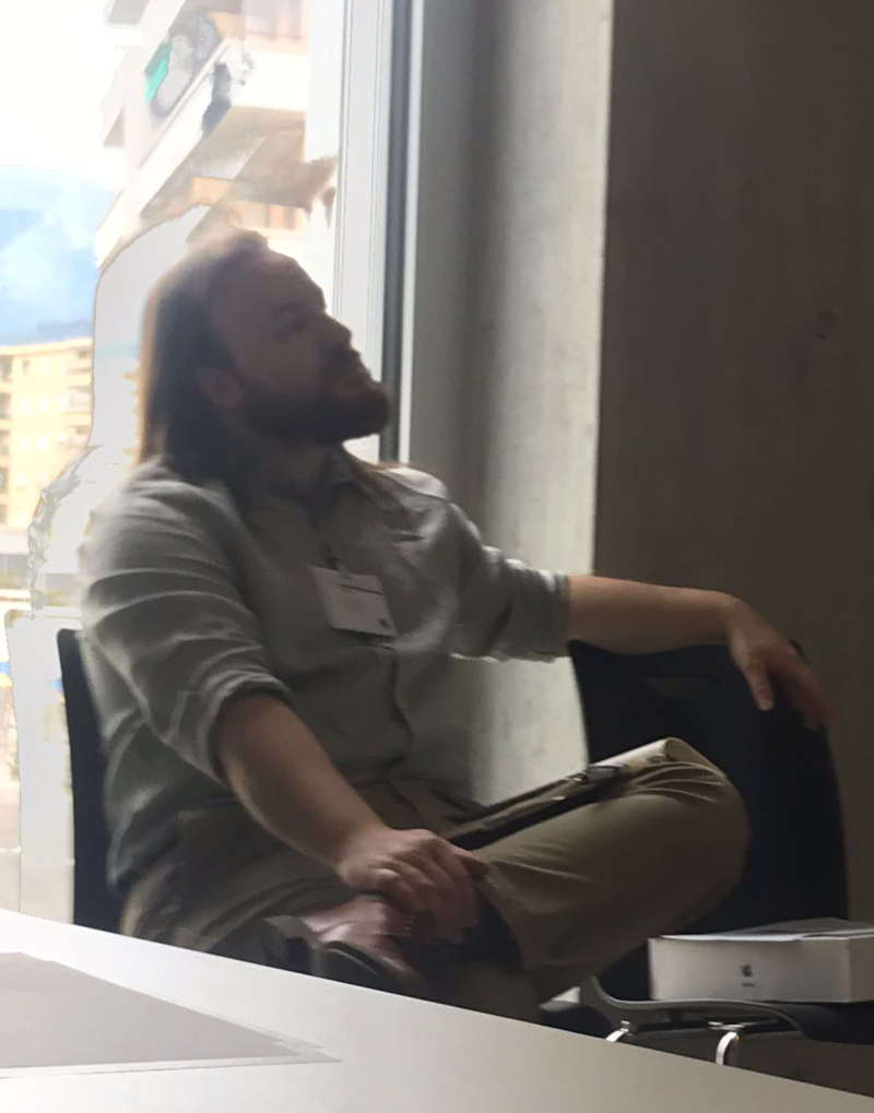 Matt Luckcuck watching a presention while he chairs a session at iFM2022, he looks like he's deep in thought.